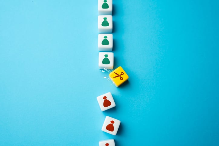 A series of dice with a bag on them illustrating cost cuts